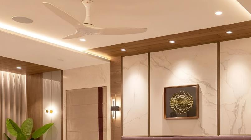 White ceiling fan with POP false ceiling in a modern master bedroom.
