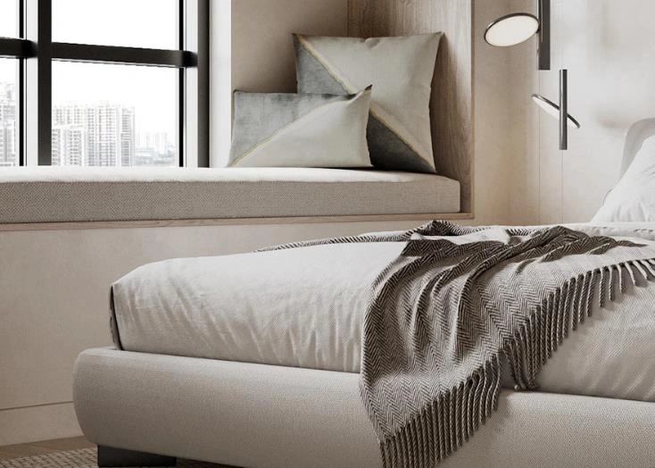 Upholstered bay window seating area in a small apartment bedroom.