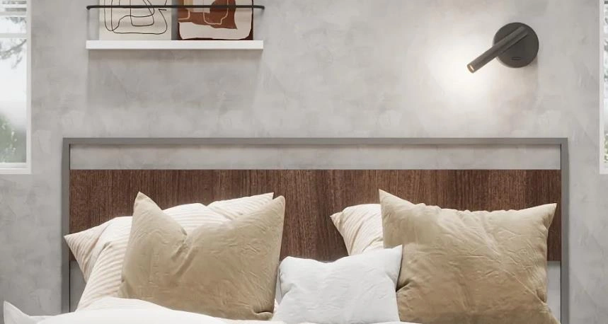 Adjustable bedside spotlight in gray finish, highlighting artwork and reading area in small bedroom.