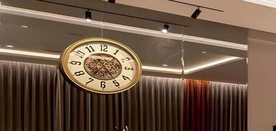 Vintage copper clock with exposed gears on wall, warm retro living room accent.