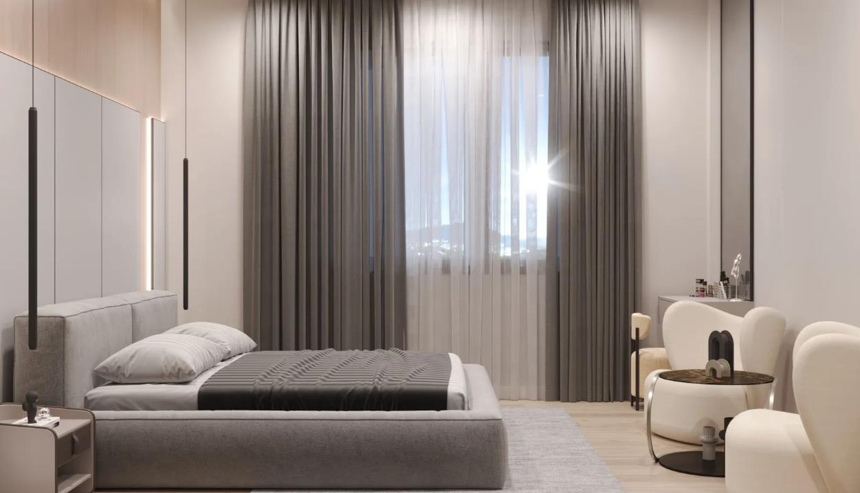 A minimalist gray master bedroom with layered curtains and simple décor